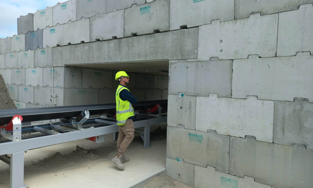 Interbloc ROM pad retaining wall with conveyor at a mine site