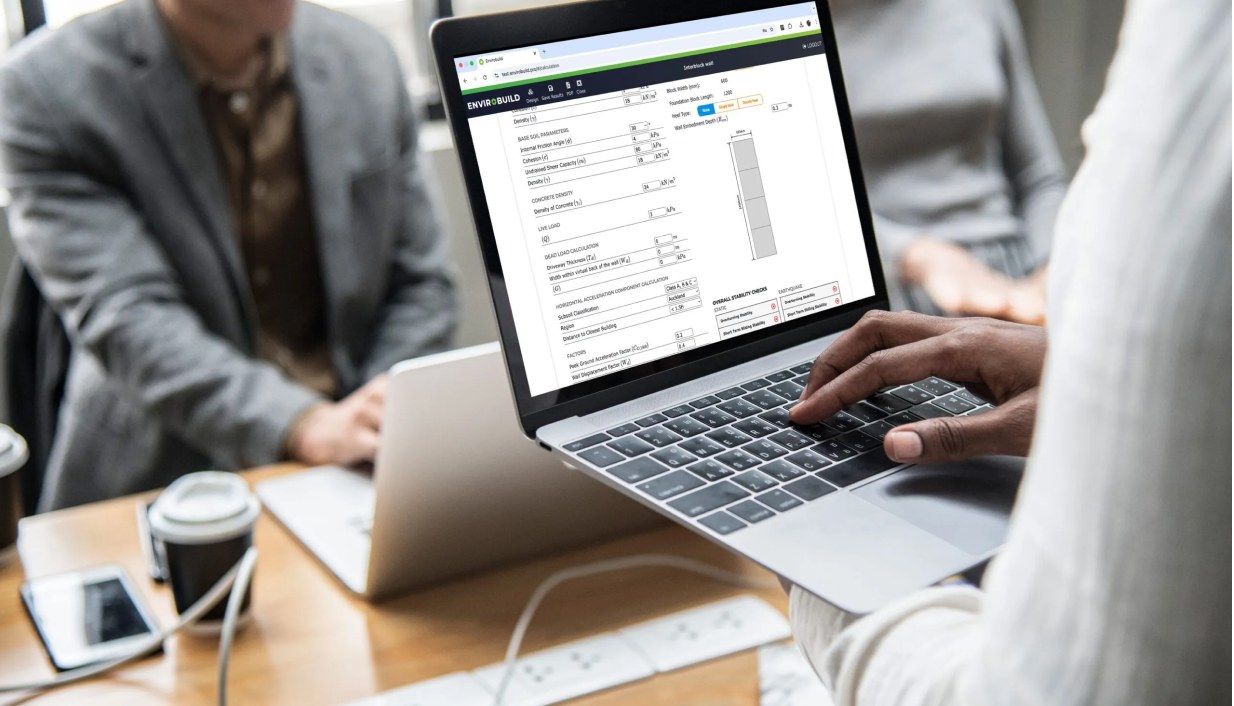 Engineer reviewing an Envirocalc structural report on a laptop