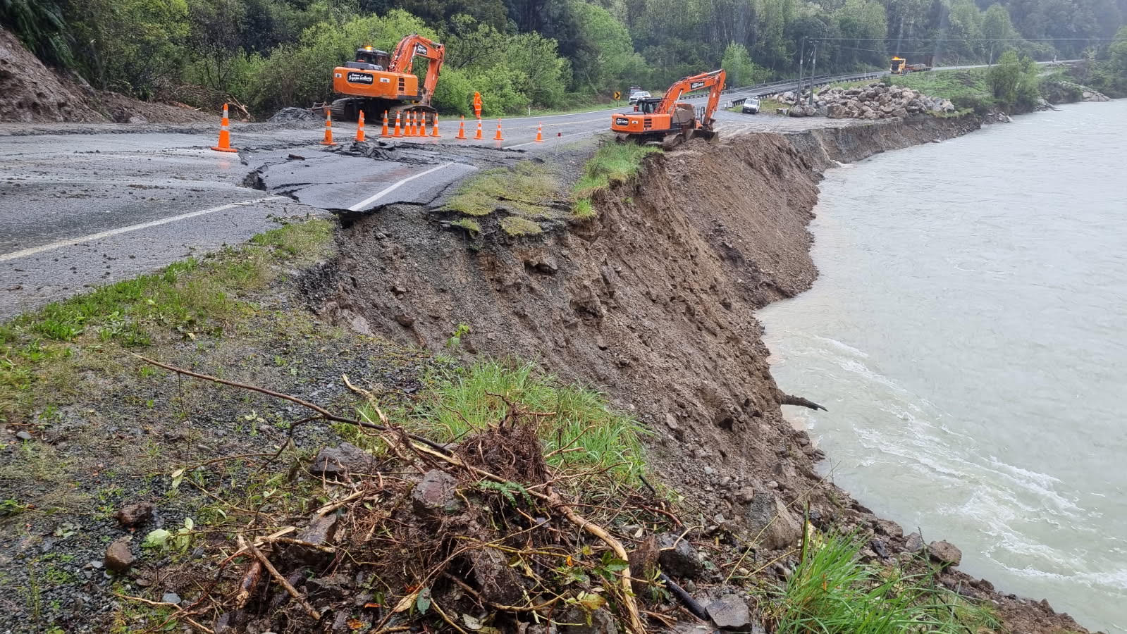 Washed-out section of State Highway 6 near Coal Creek, with excavators working the riverbank edge