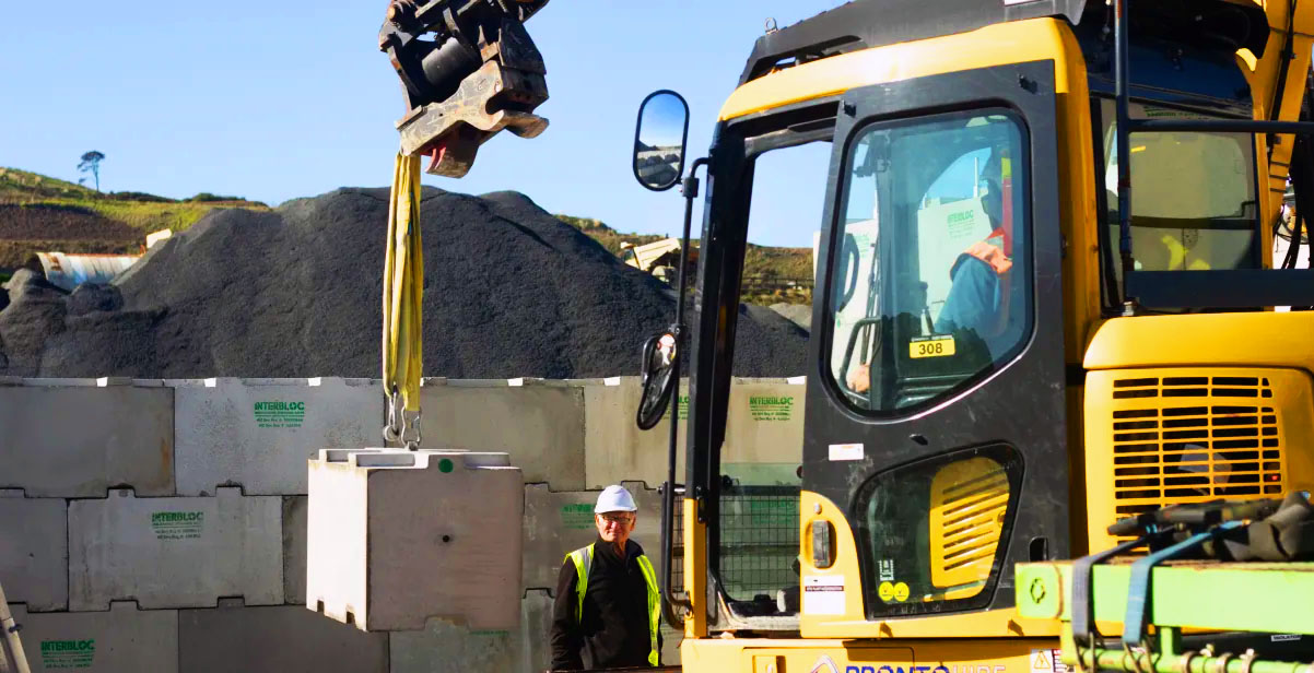 Truck-mounted crane placing an Interbloc block at a quarry site