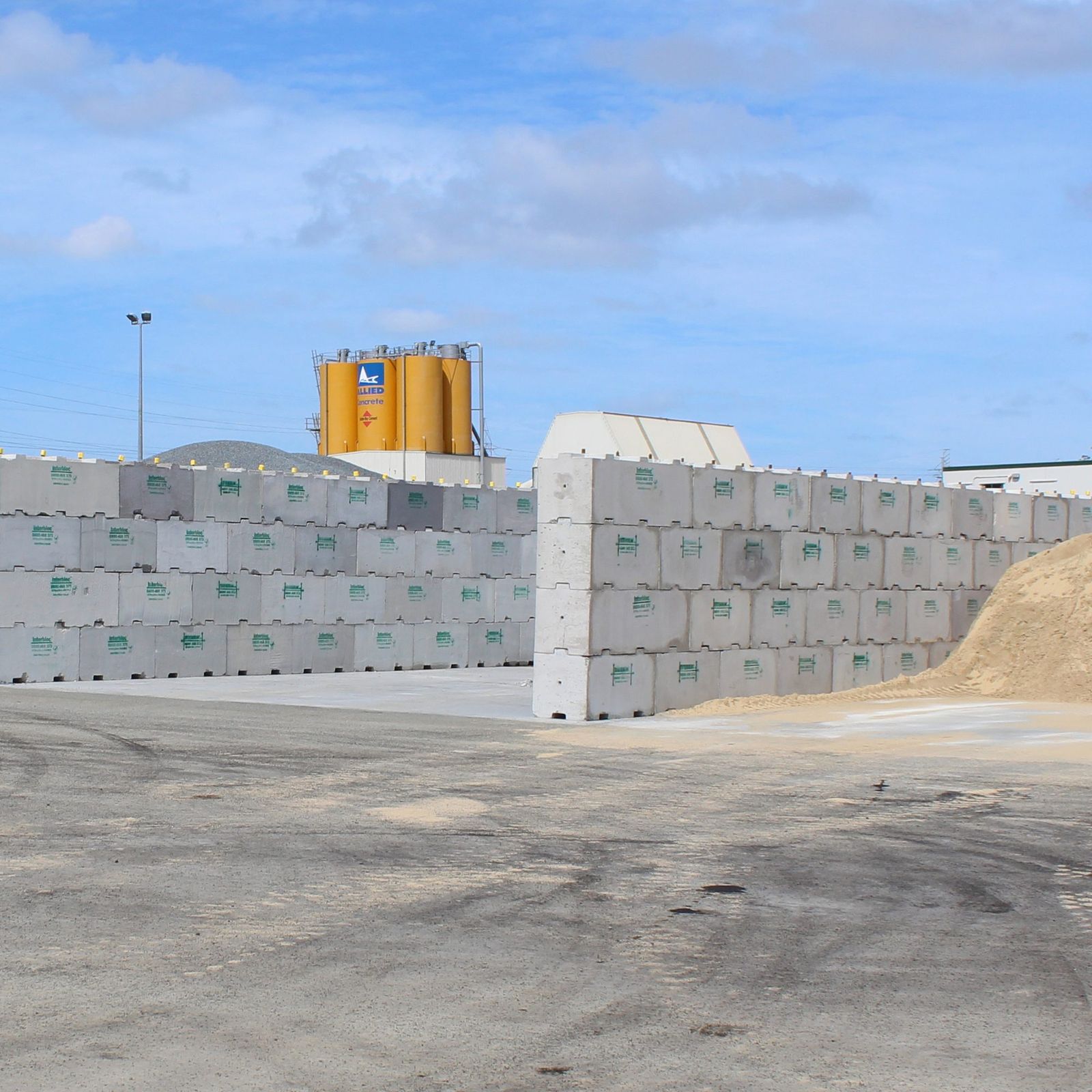 Interbloc storage walls at an industrial site with silos behind