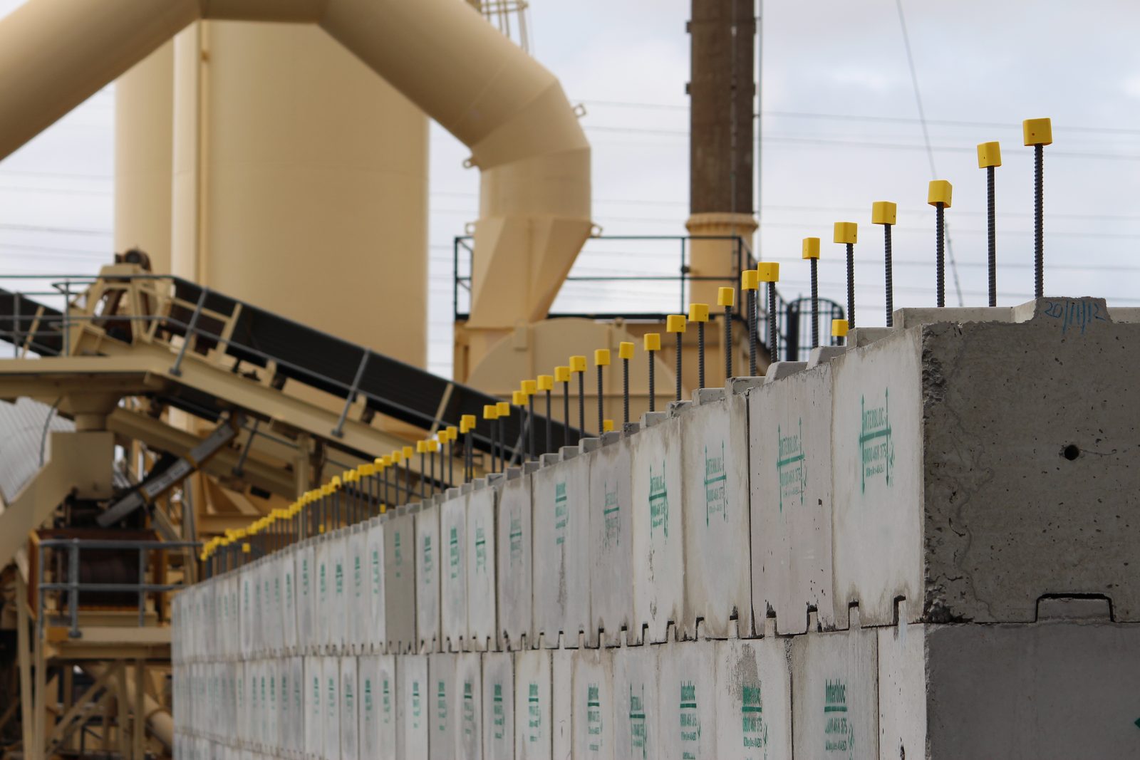 Interbloc wall alongside an asphalt plant conveyor